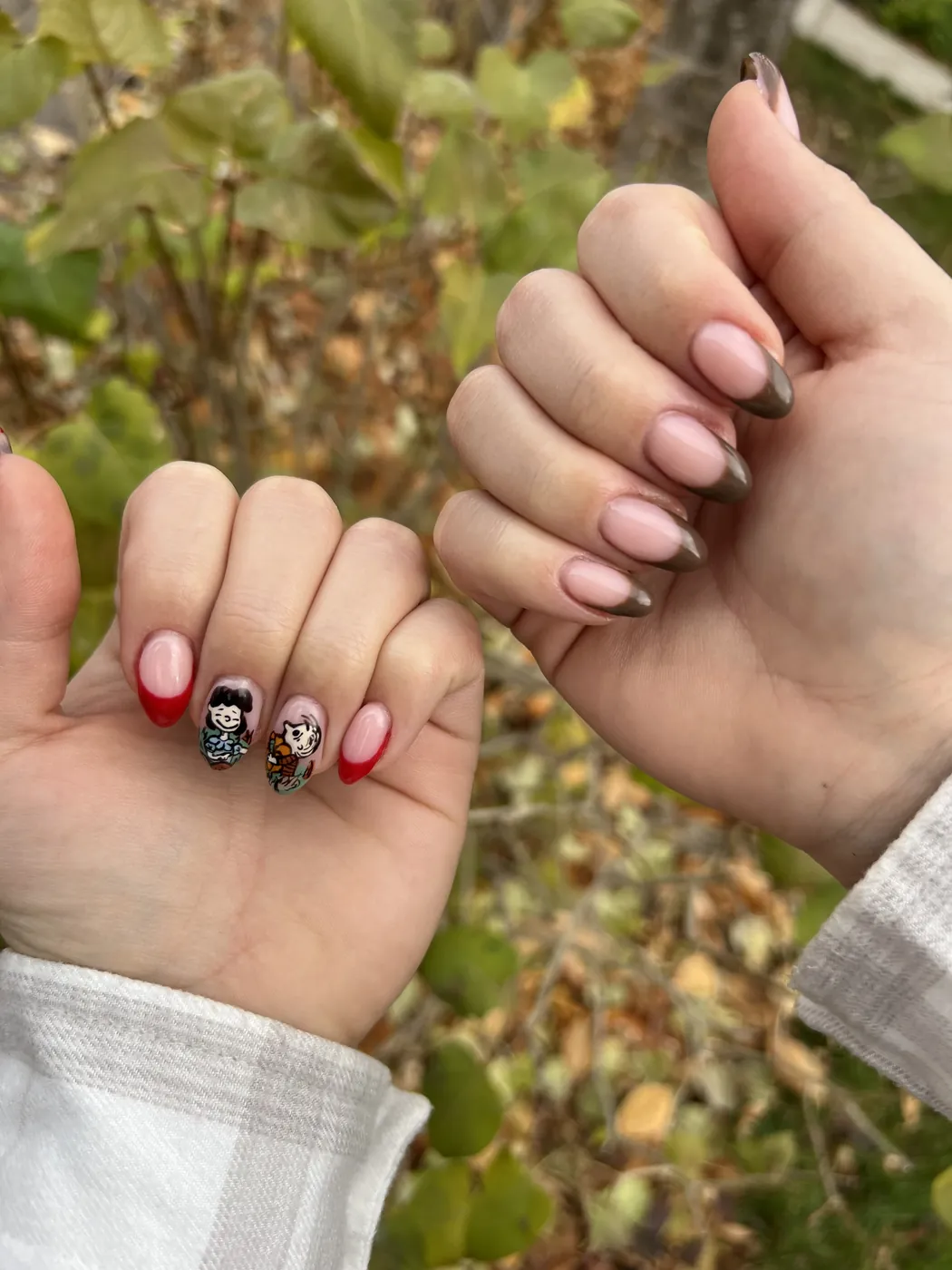 Red French tips with hand-painted character accents next to a soft brown French set